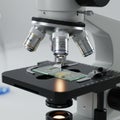 A laboratory microscope with multiple objective lenses focuses on a circuit board. Royalty Free Stock Photo