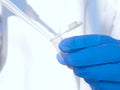 Laboratory researcher or nurse pipets patient sample into a test tube. Genetic engineering or genetic disease screening