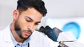 Laboratory scientist using microscope to examine monkeypox virus and note his discovery. Closeup of serious biochemist Royalty Free Stock Photo