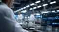 A laboratory setting features a male scientist in focus, wearing a lab coat. A computer screen displays detailed scientific data Royalty Free Stock Photo