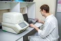 Laboratory specialist examines the data obtained on a special apparatus for analyzing samples on a computer