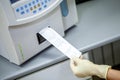 Laboratory specialist receives an extract on the composition of blood components after processing in a special apparatus, close-up Royalty Free Stock Photo