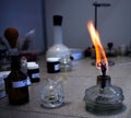 Laboratory table on which there are vials and a container with a burning wick.