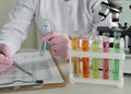 Laboratory technician conducting chemical experiments with colorful test tubes and microscope at a science facility concept Royalty Free Stock Photo