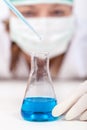 Laboratory technician dropping reagent into an erlenmeyer flask Royalty Free Stock Photo