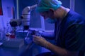 Laboratory technician preparing sample to examine under microscope