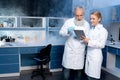 Laboratory technicians in lab coats looking at digital tablet during work in laboratory Royalty Free Stock Photo