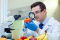 Laboratory worker examining fruits and vegetables and making analysis for pesticides and nitrates.