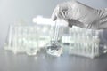 Laboratory worker holding flask with water on blurred background Royalty Free Stock Photo