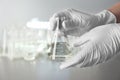 Laboratory worker holding flask with water on blurred background Royalty Free Stock Photo