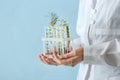 Laboratory worker holding test tubes with plants on color background, closeup Royalty Free Stock Photo