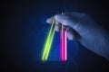 Laboratory worker holding test tubes with water on black background Royalty Free Stock Photo