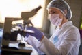 Laboratory worker looking samle through microscope