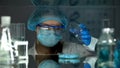 Laboratory worker opening petri dish with blue pigment, detergents production