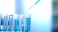 Laboratory worker pouring blue liquid in tubes, cleaning detergent production