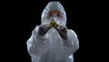 Laboratory worker in protective suit showing biological hazard symbol, weapon