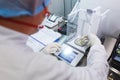 Laboratory worker in sterile rubber gloves, weighs the manufactured tablets on the control scales.