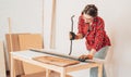 Laborer girl with crowbar in her hands pulls nails out of the board