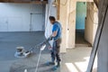 Laborer polishing sand and cement screed floor.