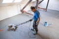 Laborer polishing sand and cement screed floor.