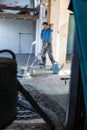 Laborer polishing sand and cement screed floor.