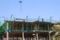 Laborers working in the construction of houses with the transport of iron formwork in a crane to lift the material