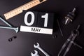Labour day. May 1st. Day 1 of may month, calendar on black background with workers tools Royalty Free Stock Photo