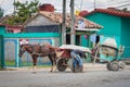 Labour man pumping tires of typical Cuban vehicle combination with horse and concrete mixer