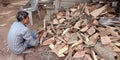 A labour picking wood logs from the wastage stock