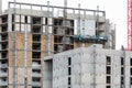 Labours work on lift platform on new development in London Docklands. Profile site view on walls