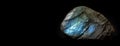 Labradorite is a rare precious natural stone on a black background. AI generated. Header banner mockup with space. Royalty Free Stock Photo