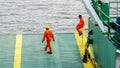 Labuan,Malaysia-July 29,2019:Crew worker in orange coveralls & wearing protective equipment helmet standing on edge of deck while