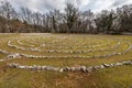 Labyrinth made of white stones on a green meadow near Beli on a sunny day in spring