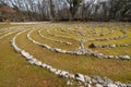 Labyrinth made of white stones on a green meadow near Beli on a sunny day in spring