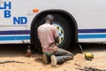 Unidentified Senegalese man checks in the car wheel.