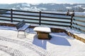 Lac view from village house. Snowy Winter rustic landscape. Wooden bench and stone table in the snow Royalty Free Stock Photo