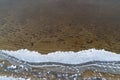 Lace patterns of the frozen water edge on the pond.