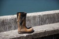 Lace up rubber boot discarded at the sea front