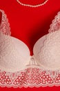 Lace white bra and a string of pearls on a red background Royalty Free Stock Photo