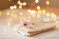 Laced paer handwriten letters with dry flowers over glow lights at background on table in room.