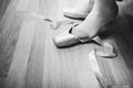Lacing ballet slippers. Ballerina laces the ribbons of the pointes. BW lifestile photo. close-up of legs