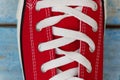 Lacing on a retro sneaker, close-up, on a blue wooden background