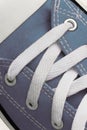 Lacing on a retro sneaker, close-up, on a blue wooden background