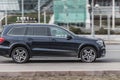 Lack full-size luxury SUV Mercedes-Benz GL-Class X166 rides in the city street. Side view of fast moving big crossover car on the Royalty Free Stock Photo