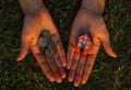 Lack of money to buy a house concept. Man holds toy house in one hand and handful of coins in another.