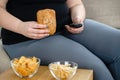 Fat woman watching series at tv eating junk food Royalty Free Stock Photo