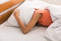 Lack of sleep. Woman covering head with pillow