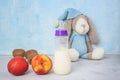 Lactation and healthy food. Breastfeeding mom`s diet. Brest milk, children`s toy, fruits on blue background. Copyspace