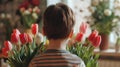 Lad with bunch of beautiful tulips behind back preparing surprise for mother Royalty Free Stock Photo