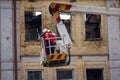 Ladder cart with the fire against the background of the facade of the burned building